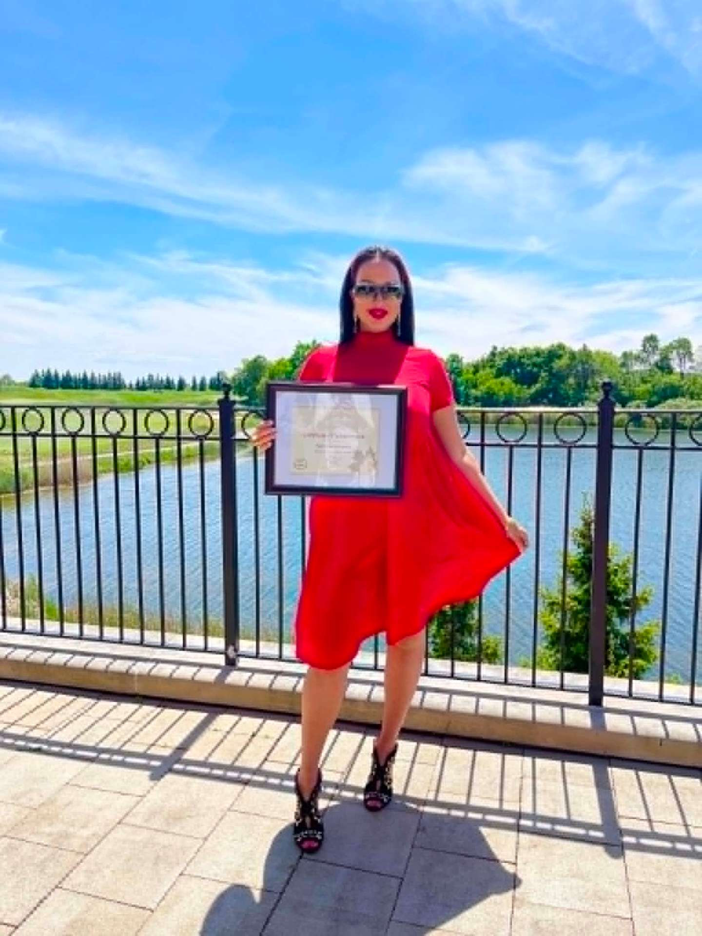 Nazrin Amirbayova holding a framed Platinum Award certificate